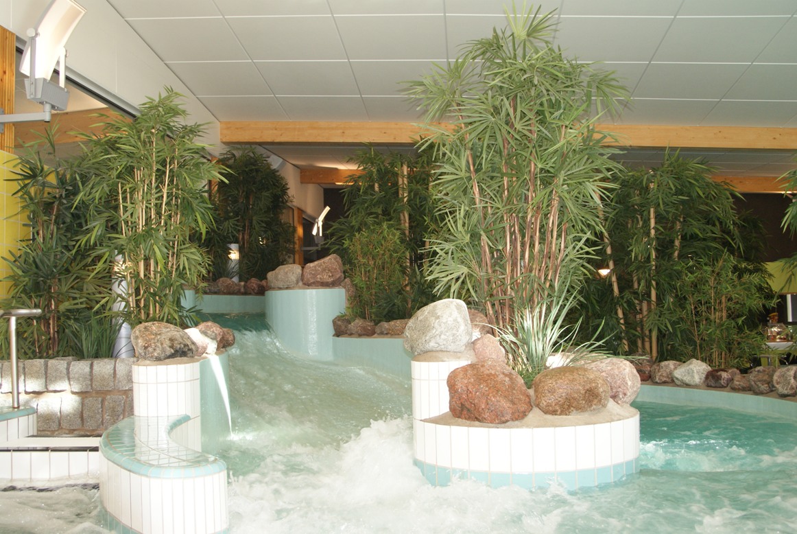 Konstgjorda palmer och konstgjord bambu i äventyrsbad.
