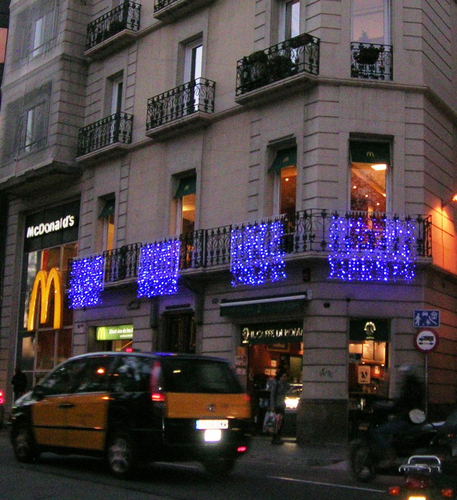 Ljusdraperier med blå leds och snowfalls på Mc Donalds i Barcelona
